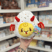 Mini Squishable Deviled Egg plush toy held in hand, front view with white egg body, yellow face and red devil horn details