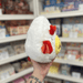 Mini Squishable Deviled Egg plush toy held in hand, side view showing white plush body, red horn and devil wing detail