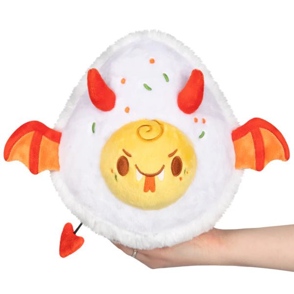 Mini Squishable Deviled Egg plush with horns, bat wings and heart tail, held in hand