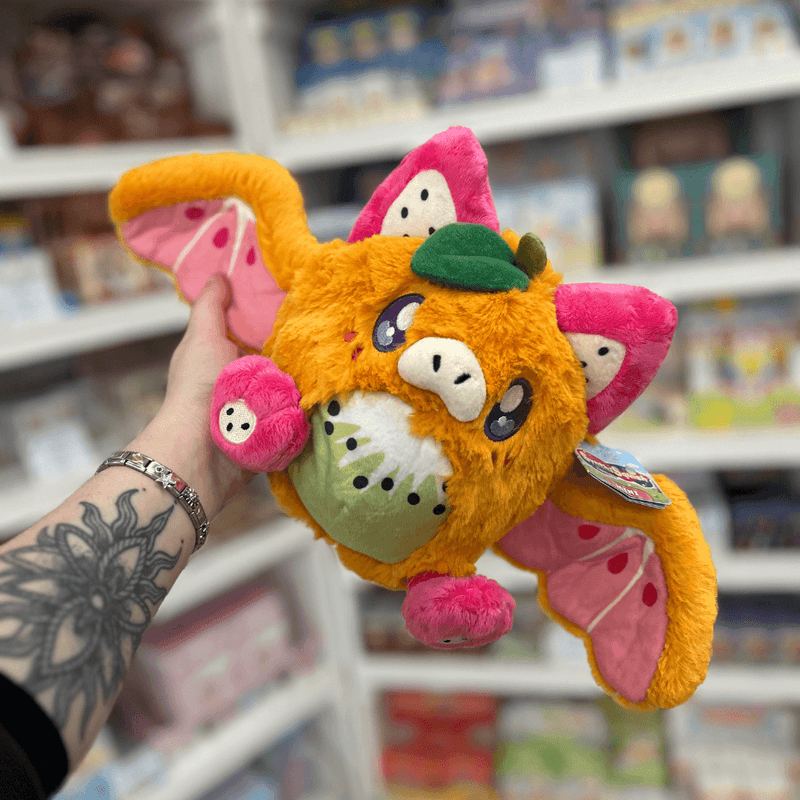 Mini Squishable Fruit Bat plush toy held in hand with wings open and tag visible