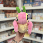 Mini Squishable Orchid Mantis plush toy held in hand, front view showing the pink body, pale fluffy underside, large embroidered eyes and green antennae