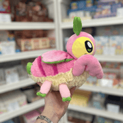 Mini Squishable Orchid Mantis plush toy held in hand, side profile showing the pink segmented body, folded wings, green antenna and plush insect shape