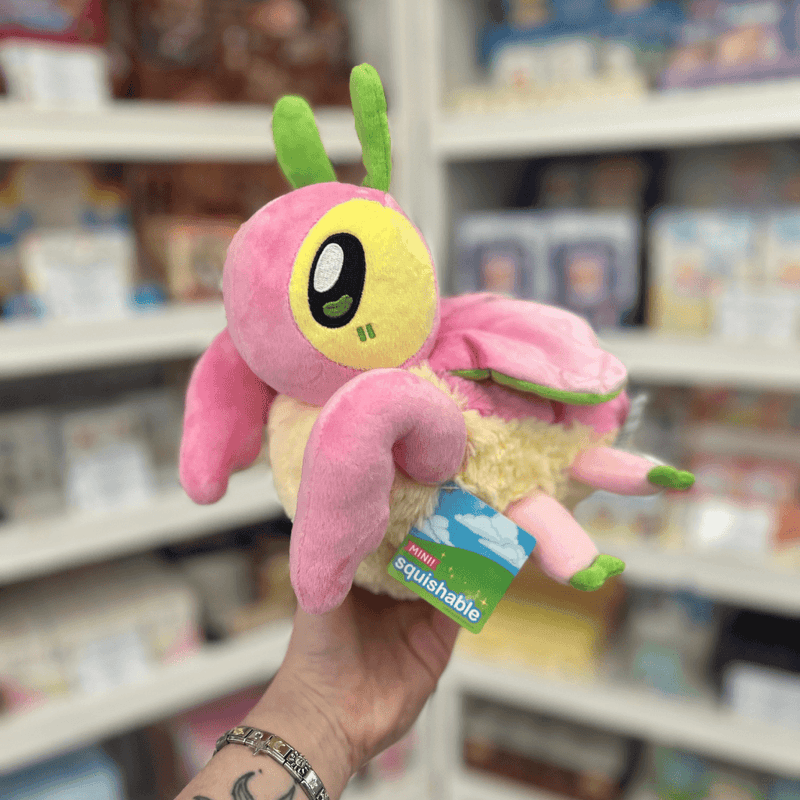 Mini Squishable Orchid Mantis plush toy held in hand, angled side view showing the pink wings, curved front legs, green details and soft cream underside