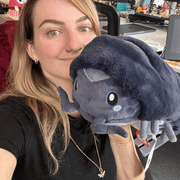 Person holding Mini Squishable Pillbug Rollie Pollie plush toy, showing its size and soft texture.