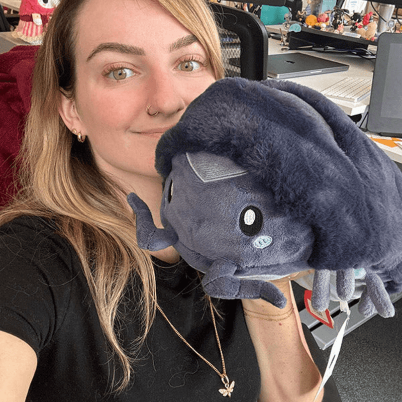 Person holding Mini Squishable Pillbug Rollie Pollie plush toy, showing its size and soft texture.