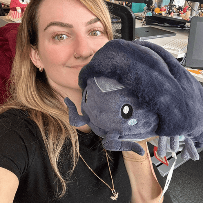 Person holding Mini Squishable Pillbug Rollie Pollie plush toy, showing its size and soft texture.