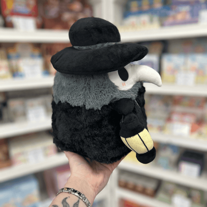 Mini Squishable Plague Doctor plush toy held in hand, side view