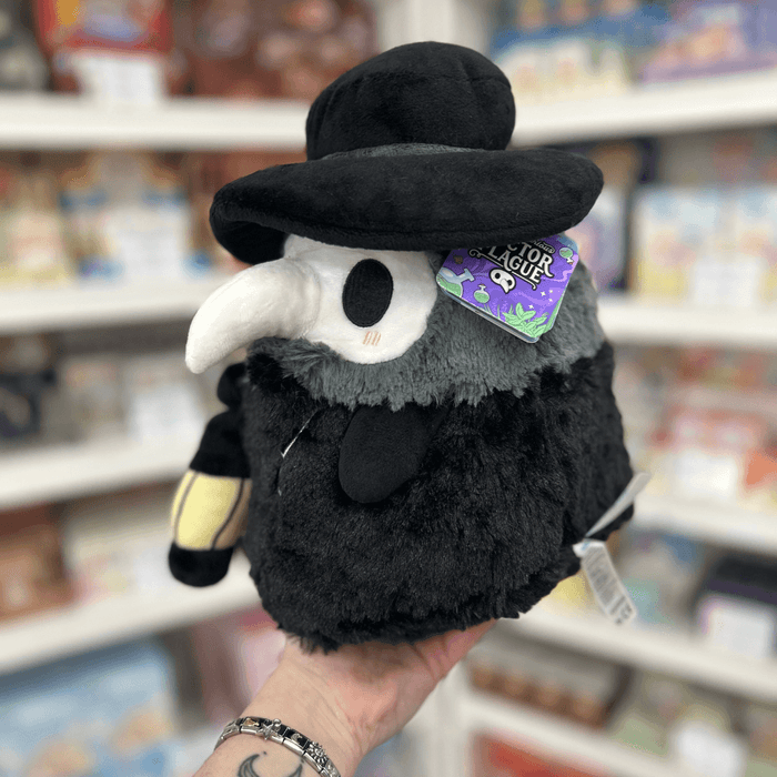 Mini Squishable Plague Doctor plush toy held in hand with tag visible