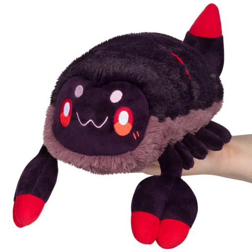 Mini Squishable Scorpion plush toy, black and charcoal scorpion with bright red claws and tail, held in hand.
