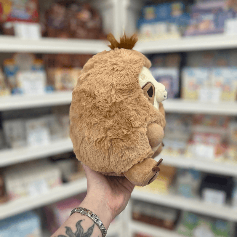 Mini Squishable Sleepy Sloth plush toy held in hand, side and back view showing the soft plush texture, rounded shape and tuft of fur on top