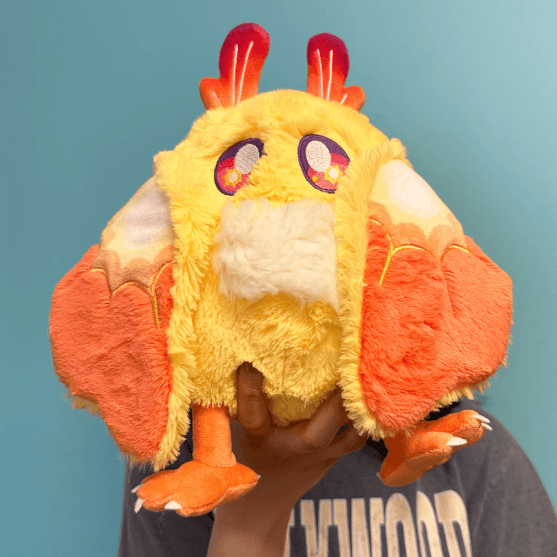 Mini Squishable Solar Mothman plush being held
