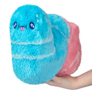 Mini Squishable Sour Gummy Worm plush in blue and pink with sparkly eyes, held in hand