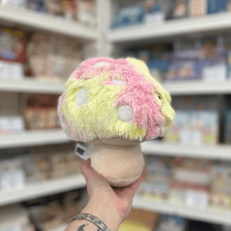 Mini Squishable Tie Dye Mushroom plush toy back view held in hand in a shop