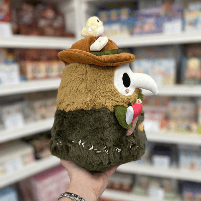 Mini Squishable Woodland Plague Doctor plush toy held in hand, side view