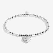 Full view of Joma Jewellery A Little Love You To The Moon & Back Bracelet, silver-plated beaded stretch Bracelet with moon heart charm.