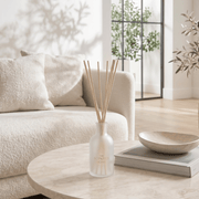The Scented Home reed diffuser styled on a marble coffee table in a bright neutral living room