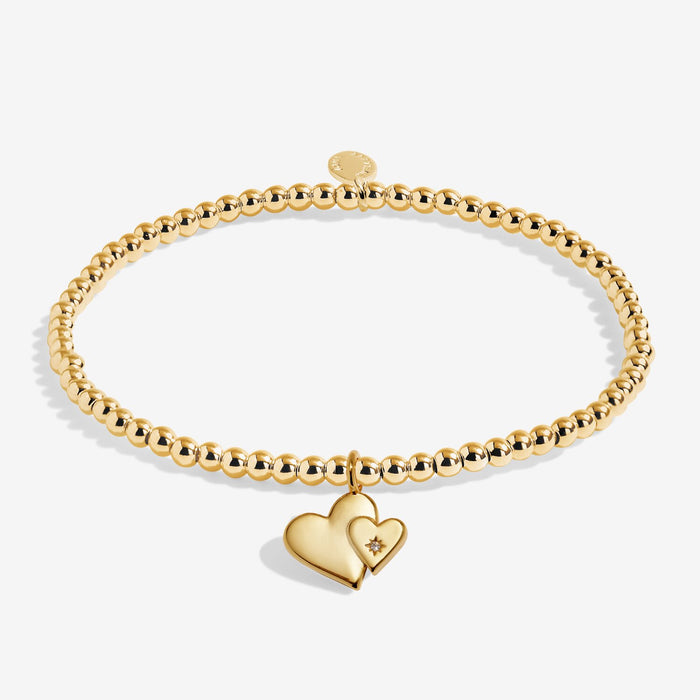 Full view of Joma Jewellery A Little Mother & Daughter Bracelet, gold-plated beaded stretch Bracelet with double heart charm.