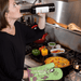 Woman cooking with My Favorite Salad Is Wine oven mitt while drinking wine.

