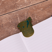 Gold brass Neverland metal bookmark placed inside an open book
