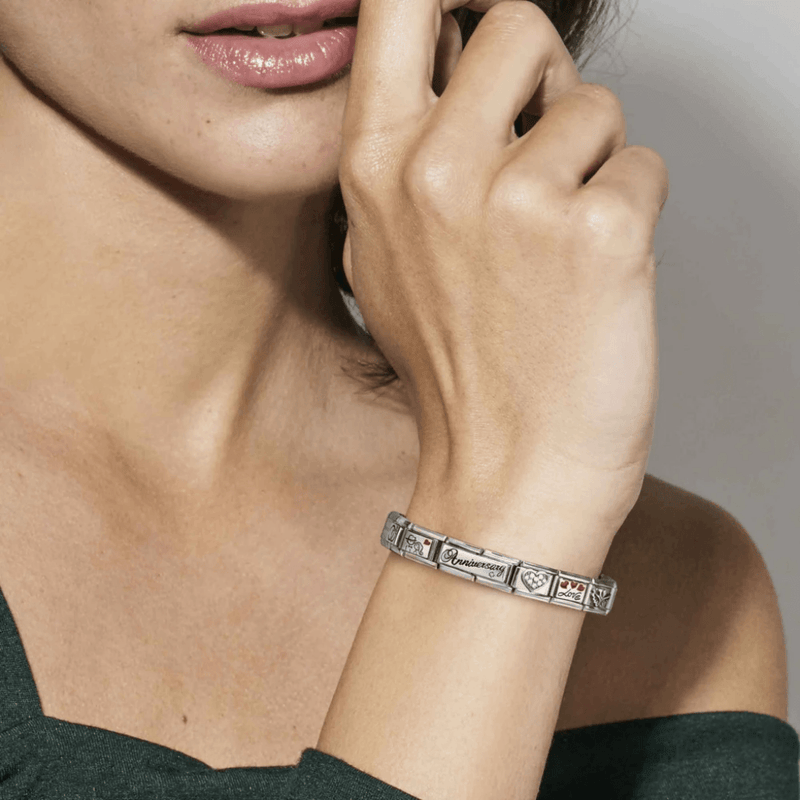 Woman wearing a Nomination Composable bracelet featuring the Anniversary Double Link alongside other love-themed charms.