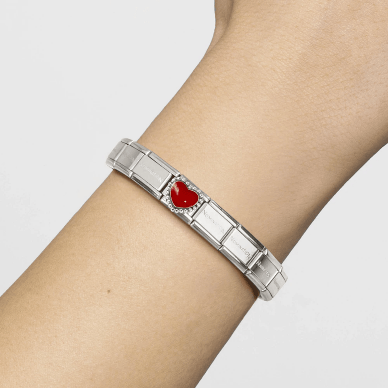 Nomination Classic stainless steel bracelet worn on the wrist featuring a glossy red enamel heart with silver beaded setting.