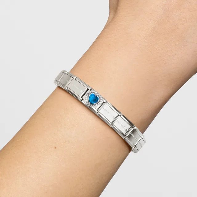 Nomination Classic bracelet on wrist featuring faceted blue heart link with beaded sterling-silver setting on stainless steel