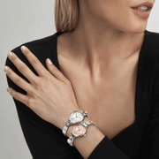 Model wearing two Nomination Composable watches with silver and pink-toned dials.