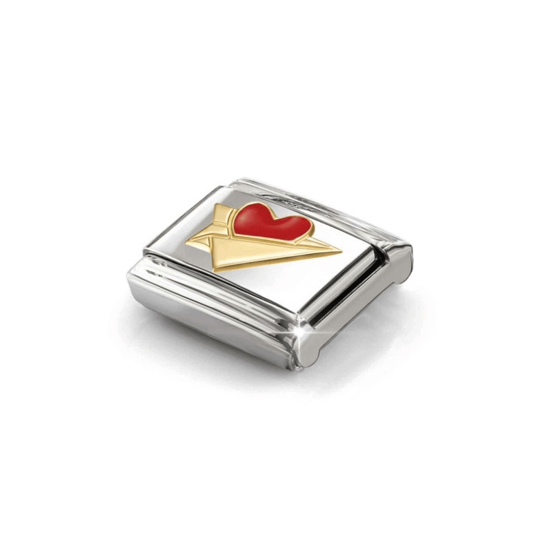 Angled close-up of Nomination Gold Paper Aeroplane Charm showing raised yellow-gold wings and a bright red enamel heart.