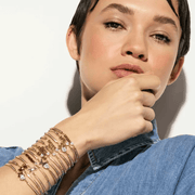 Model wearing stacked Nomination Milleluci adjustable bracelets including the BEST FRIEND yellow gold-tone design