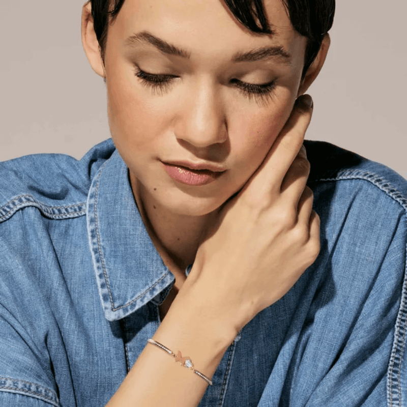 Model wearing Nomination Milleluci Butterfly bracelet in rose gold-tone PVD with white cubic zirconia heart