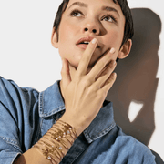 Model wearing stacked Nomination Milleluci bracelets including the rose gold-tone four leaf clover design