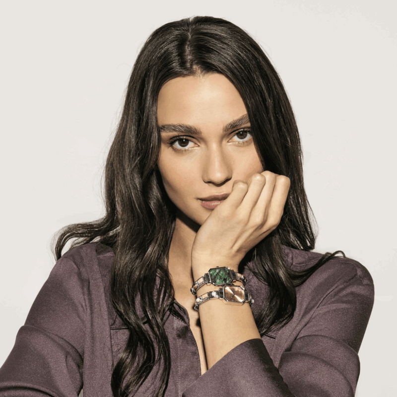 Model wearing two Nomination Paris watches with green and gold-tone rectangular dials and personalised Composable straps.