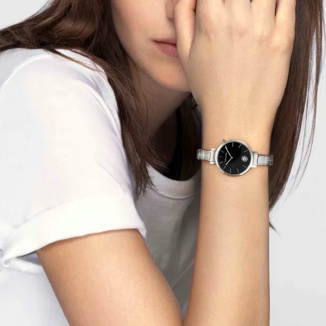 Woman wearing a Nomination Time round watch with sunray black dial on a stainless steel Composable strap.