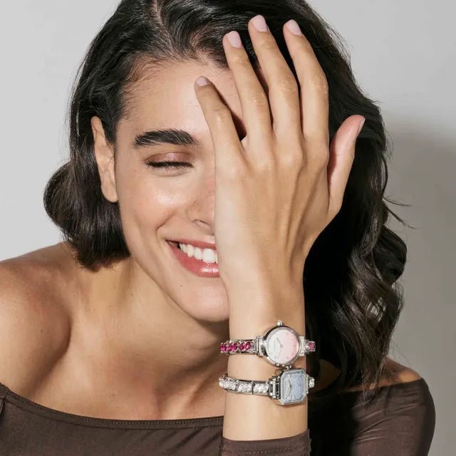 Woman wearing two Nomination Time watches: round pink dial and octagonal CZ-bezel style on Composable straps.