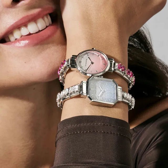 Model stacking Nomination Time watches with Composable straps; round pink dial and octagonal CZ-bezel watch.