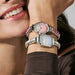 Model stacking Nomination Time watches with Composable straps; round pink dial and octagonal CZ-bezel watch.