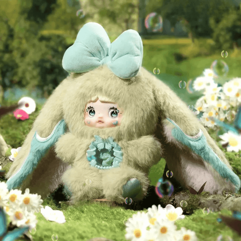 Nepenthe plush – sage‑green suit, aqua bow and butterfly core, Nommi Fantasy World collectable.
