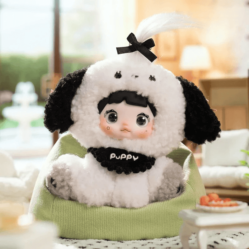 Cotton Puff Nommi Sitting Zoo plush wearing a black and white puppy costume