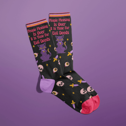 Novelty black crew socks with witchy cat, skulls, eyeballs and colourful toes on purple background