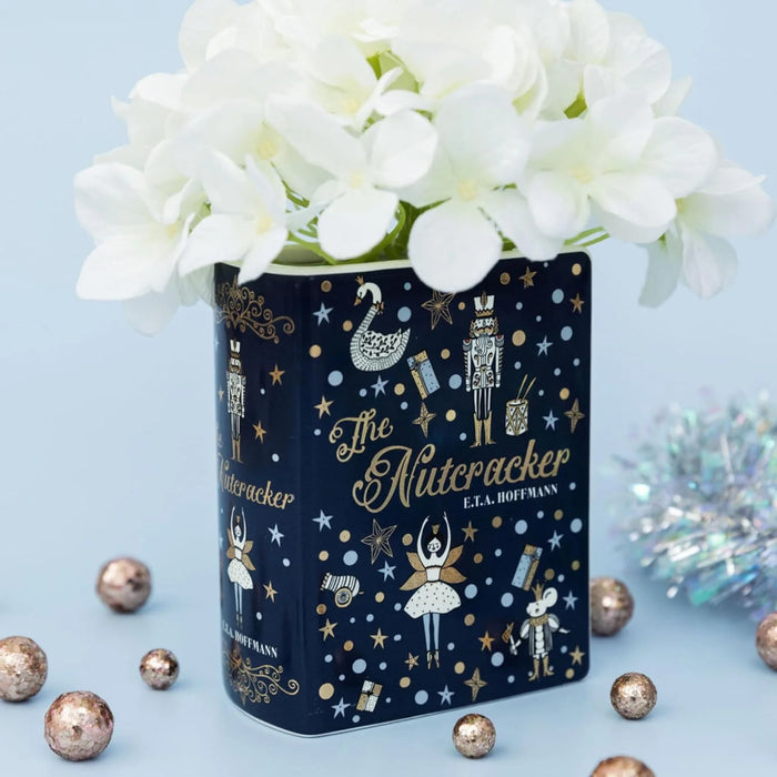 The Nutcracker book vase with white flowers on pale blue background and baubles