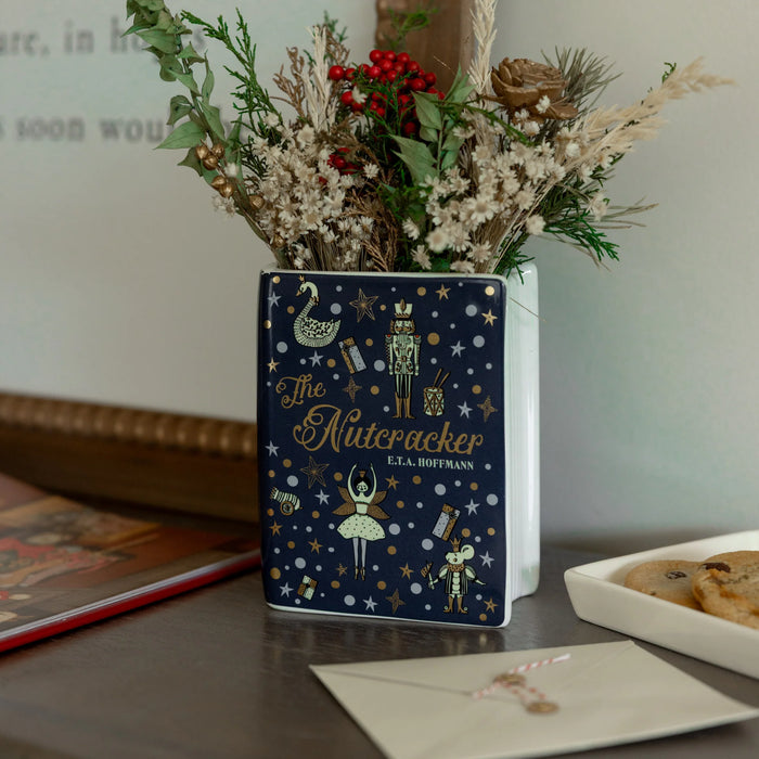 Navy Nutcracker book vase on shelf with festive sprigs and biscuits