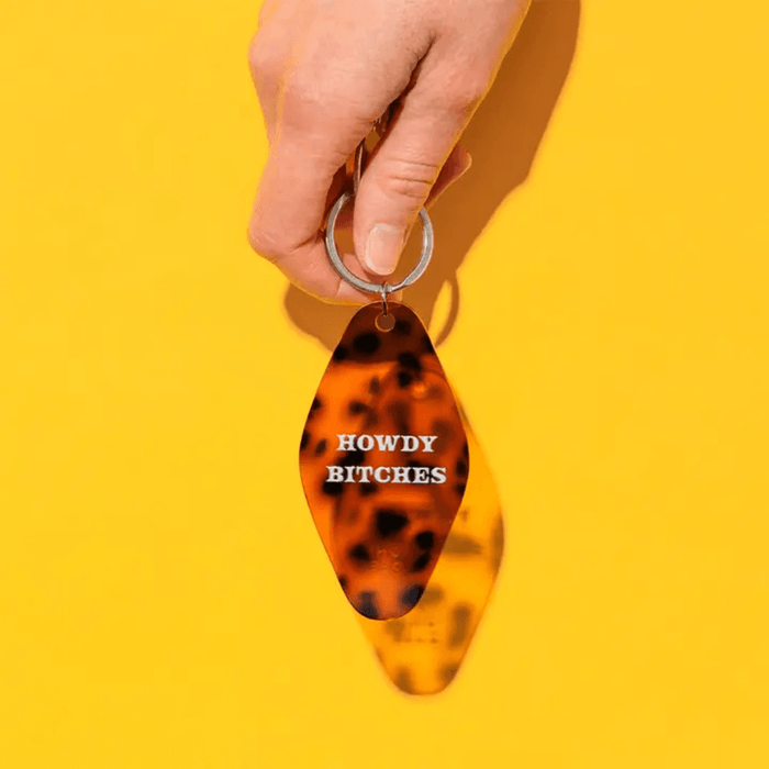 Ohh Deer Howdy Bitches keyring being held against a yellow background