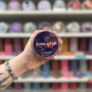 Oudh Altar wax melt pot held in hand with colourful wax melt display in the background