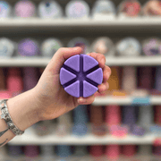 Oudh Altar wax melt segments held in hand with colourful wax melt display in the background
