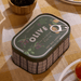 Paddywax Bistro Fig and Olive tin candle on a checked tablecloth with olives and bistro table setting