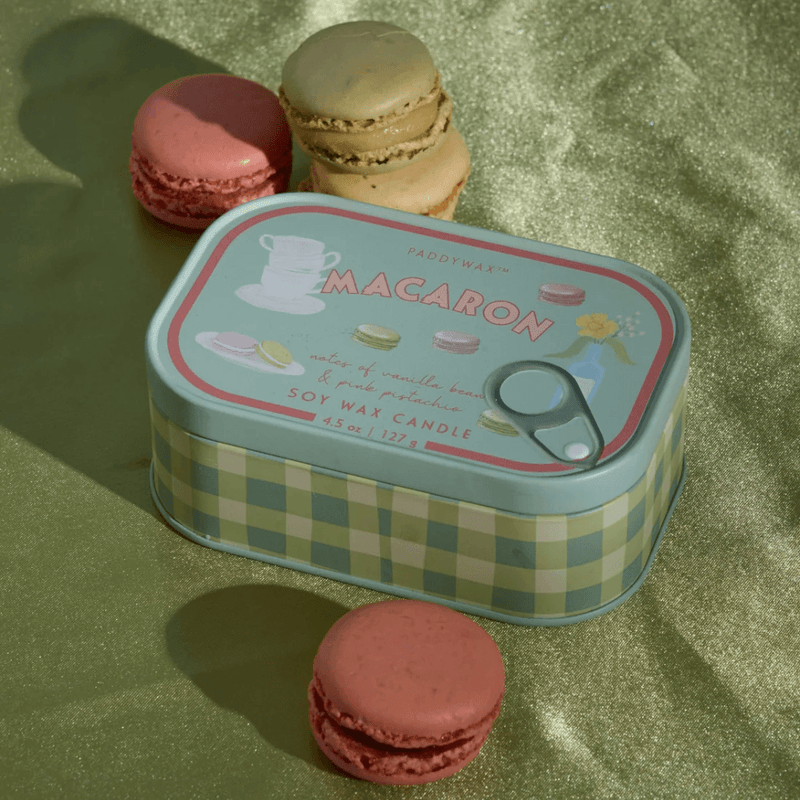 Paddywax Bistro Macaron tin candle displayed with colourful macarons