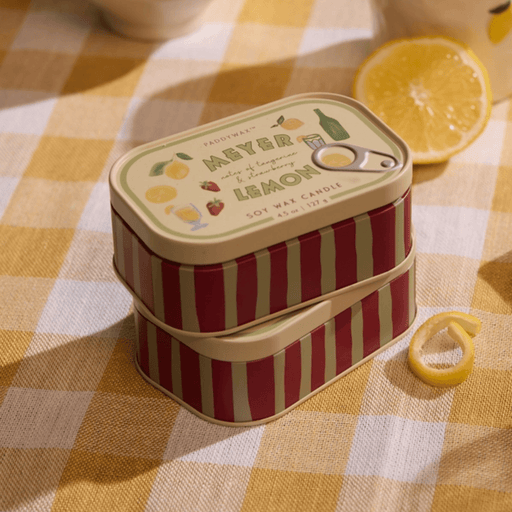 Paddywax Bistro Meyer Lemon tin candle on a checked tablecloth with lemon slices
