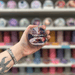 Parisian Roast wax melt pot held in hand with colourful wax melt display in the background