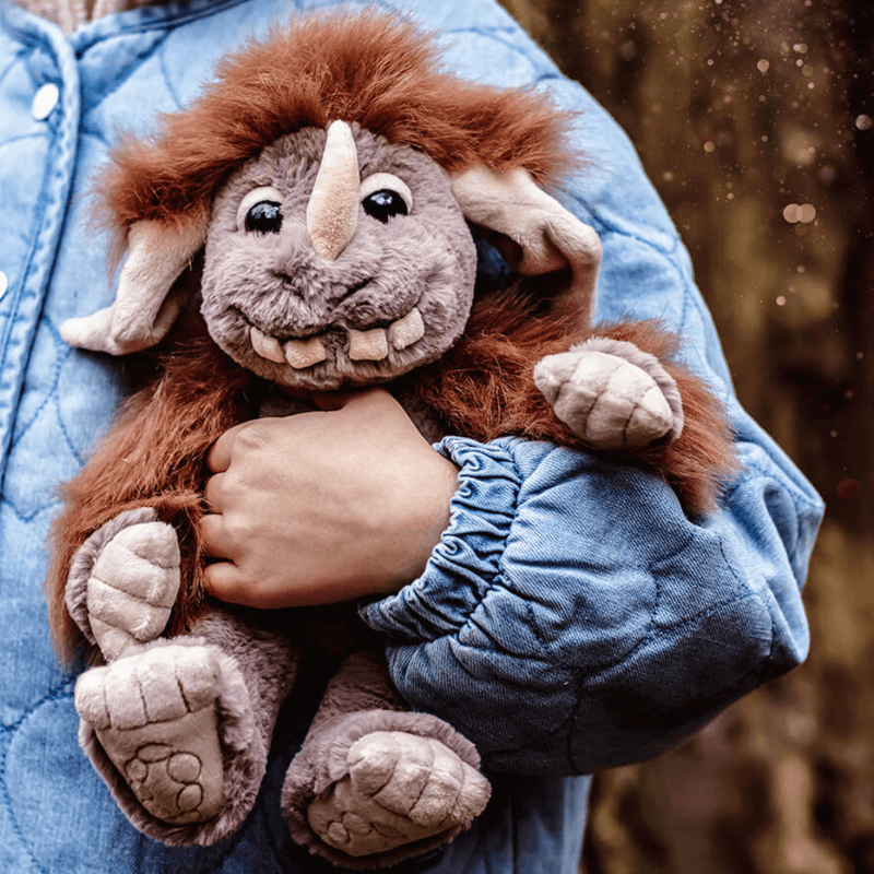 Pebble Bearhouse by Charlie Bears super-soft ogre plush toy being cuddled outdoors, showing the fluffy brown hair and grey face