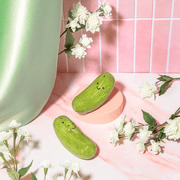 Pickle salt and pepper shakers styled with flowers on a pink kitchen surface
